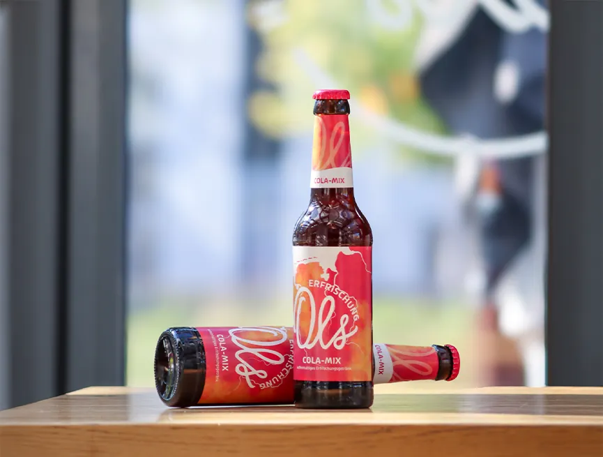 ols cola mxi brauhaus das ols kellerbier in einer flasche und im glas vor alten holzfässern